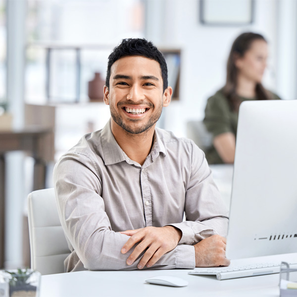 IT employee smiling at a desk